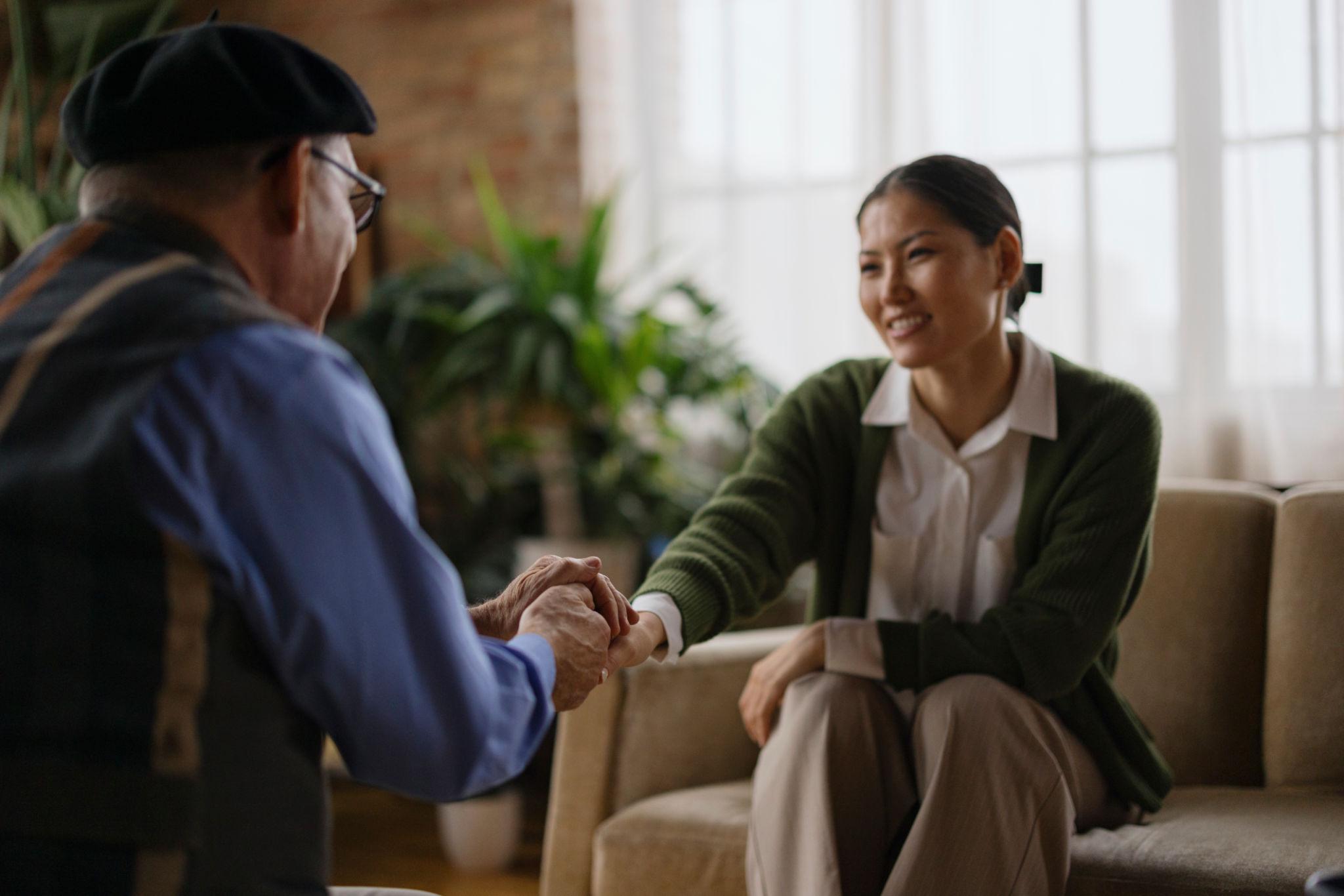 A senior and their companion sitting together, sharing a warm and easy conversation